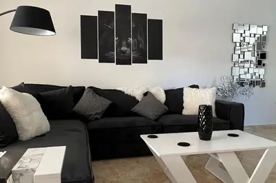 a living room with a black couch and a table at Anna Kavros luxury apartment in Chania Town