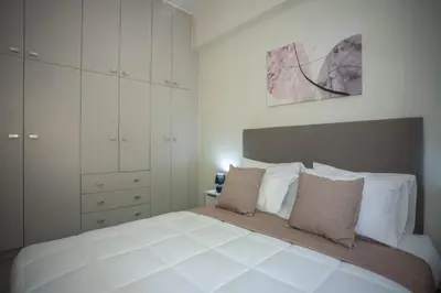 a bedroom with a large white bed with white cabinets at Makel Apartment in Chania Town