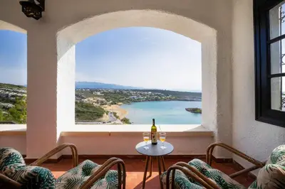 a table with a bottle of wine in a room with a window at Casa Bella Vista in Kalathas