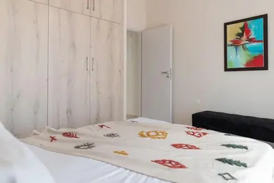 a bed with a white blanket with flowers on it at Katofli Slow Living in Pithárion