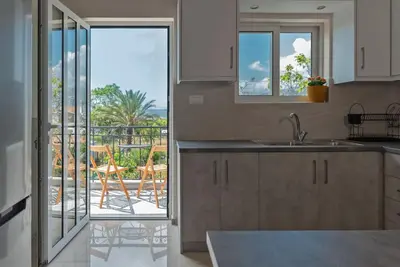 a kitchen with a view of a patio with a balcony at Katofli Slow Living in Pithárion