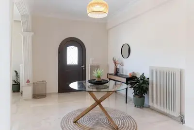 a living room with a glass table and a black door at Katofli Slow Living in Pithárion
