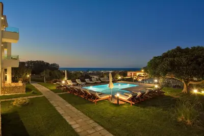 a swimming pool with lounge chairs next to a building at Panthea Luxury Living in Kolymvari