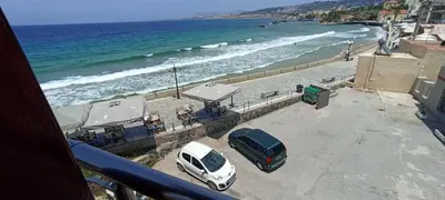 a white car parked at a beach with the ocean at Porta di Sabbia in Koum Kapi beach in Chania Town