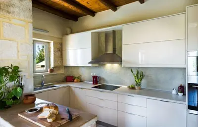 a kitchen with white cabinets and a sink at Villa Asteriskos in Áyios Andhréas