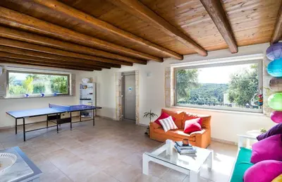 a living room with a table and a couch at Villa Asteriskos in Áyios Andhréas
