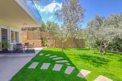 a backyard with a lawn with a stone path at Renovated apartment 3- Platanias in Plataniás