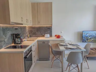 a kitchen with a table and a table and chairs at Renovated apartment 2 -Platanias in Plataniás