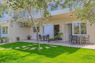 a house with a yard with a table and chairs at Renovated apartment 2 -Platanias in Plataniás
