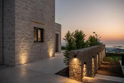 a stone house with lights on the side of it at GG Villas Falassarna in Chania Town