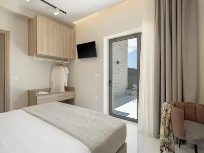 a bedroom with a bed and a sliding glass door at GG Villas Falassarna in Chania Town