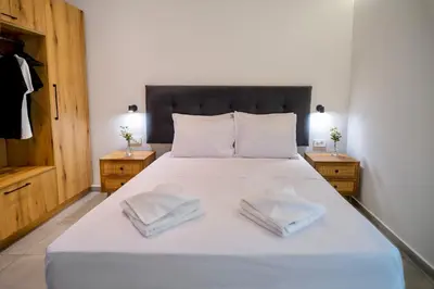 a bedroom with a white bed with two towels on it at Sweven boutique apartments in Souda