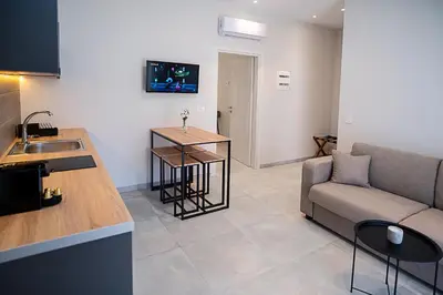 a kitchen and a living room with a couch and a table at Sweven boutique apartments in Souda