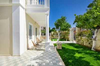a patio of a house with chairs and grass at Casa Verde Chania in Chania Town