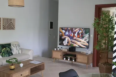 a living room with a couch and a television at E&G Relax Homes-C in Kissamos