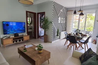 a living room with a large television and a table at E&G Relax Homes-C in Kissamos