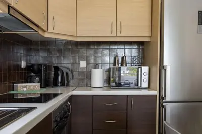 a kitchen with wooden cabinets and a white refrigerator at Christini Cozy Apartment in Souda