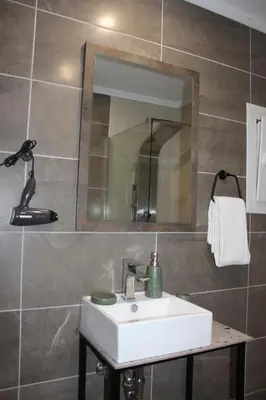 a bathroom with a white sink and a mirror at Angel's Nest in Chania Town