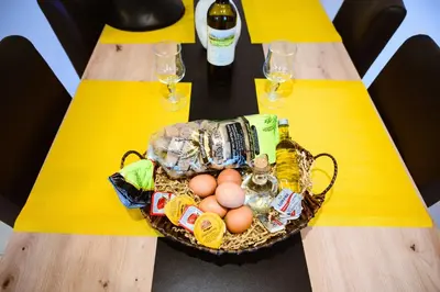 a basket of eggs on a table with wine glasses at Nikola's Vineyard in Ayiá