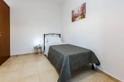 a bedroom with a bed with a gray blanket at Nikola's Vineyard in Ayiá