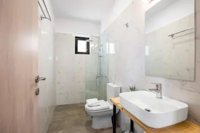 a white bathroom with a sink and a toilet at Isabel Artemis Crete - Luxury Sea Views Villas in Nopíyia