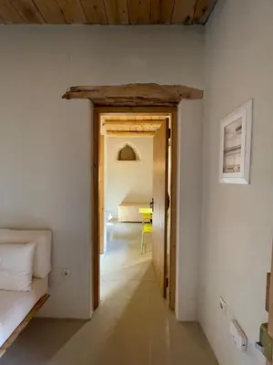 a hallway with a bedroom and a bed in a room at Petres old village house in Áyios Ioánnis
