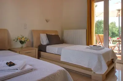 a bedroom with two beds and a balcony at Mabech Villa in Plataniás