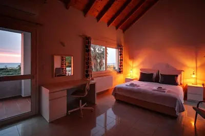 a bedroom with a bed and a desk and a window at Mabech Villa in Plataniás