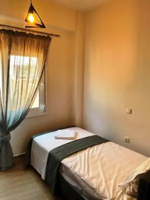 a bedroom with a bed and a window at Korina's Apartment in Daratso