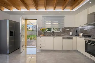 a kitchen with white cabinets and stainless steel appliances at Garden Villa Chania in Chania Town
