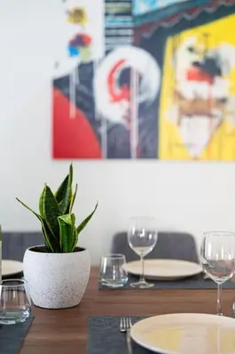 a table with a potted plant and glasses on it at Callista City Living in Chania Town