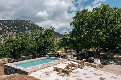 a swimming pool with two lounge chairs next to it at Nomas Home Imbros in Khóra Sfakíon