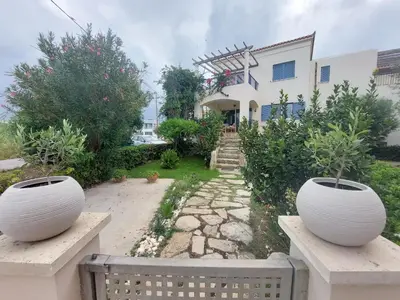 two large white vases sitting on benches in front of a house at Infinity Night Villa in Chania Town