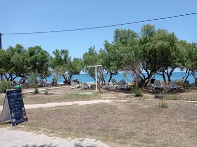 a beach with a sign and trees and the ocean at Infinity Night Villa in Chania Town