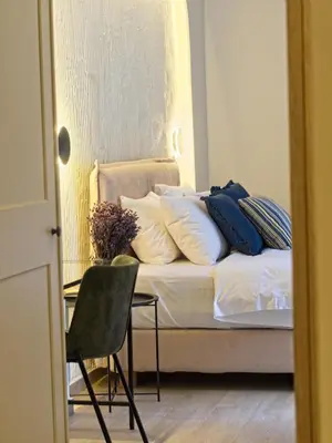 a bed with pillows and a chair in a room at Il Porto Blu in Chania Town