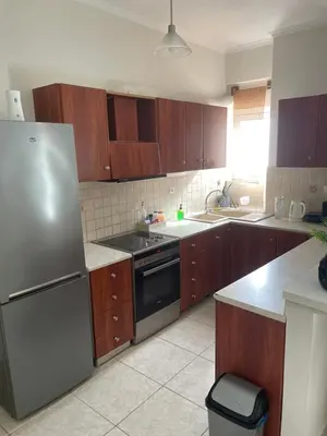 a kitchen with wooden cabinets and a stainless steel refrigerator at Tzitzifianaki apartment in Chania Town