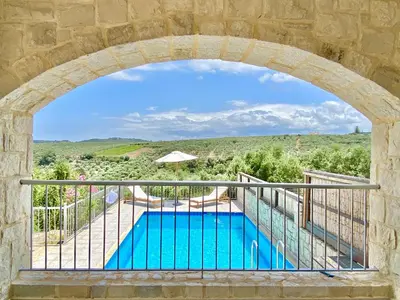 a view of a swimming pool through an archway at Villa Albama in Darmarochori