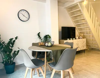 a dining room with a table and chairs and a clock at Kerdos Home in Kalyves