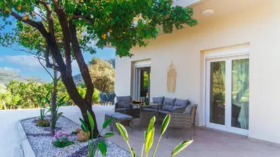 a patio with a couch and a tree at Archontissa Kakodiki - Paleochora in Áyioi Theódhoroi
