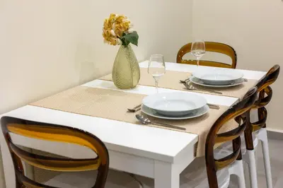 a white table with chairs and a vase with flowers at Adriana Apartment in Agia Marina Nea Kydonias