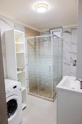 a bathroom with a washing machine and a sink at Adriana Apartment in Agia Marina Nea Kydonias