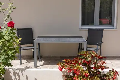 two chairs and a table on a patio at Adriana Apartment in Agia Marina Nea Kydonias