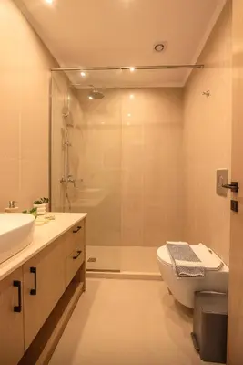 a bathroom with a shower and a toilet and a sink at Eva's apartments in Kissamos