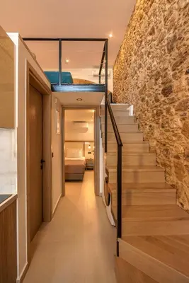 a staircase in a house with a stone wall at Eva's apartments in Kissamos