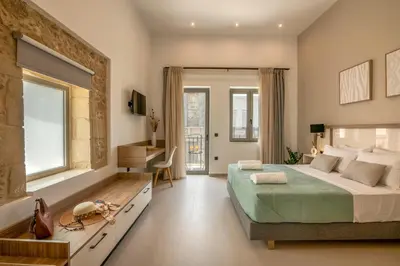 a bedroom with a large bed and a desk at Eva's apartments in Kissamos
