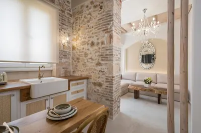 a kitchen with a brick wall and a sink and a table at il Campanile Luxury Living in Chania Town