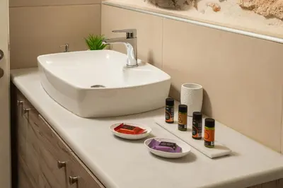 a bathroom counter with a sink and four bottles of cosmetics at Lovelia Maisonette Chania in Chania Town