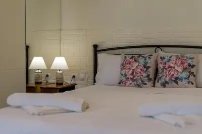 a bed with two lamps and two towels on it at Helios studio next to the sea BY APOKORONAS-VILLAS in Kalyves