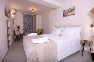 a bedroom with a large white bed with towels on it at Kabanas suite 1 in Chania Town