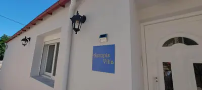 a white building with a door and a sign on it at Aeropis Villa, Chania in Chania Town